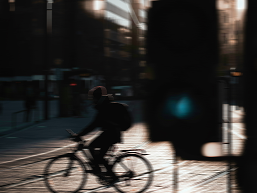 Mand cykler over vejen med sløret effekt